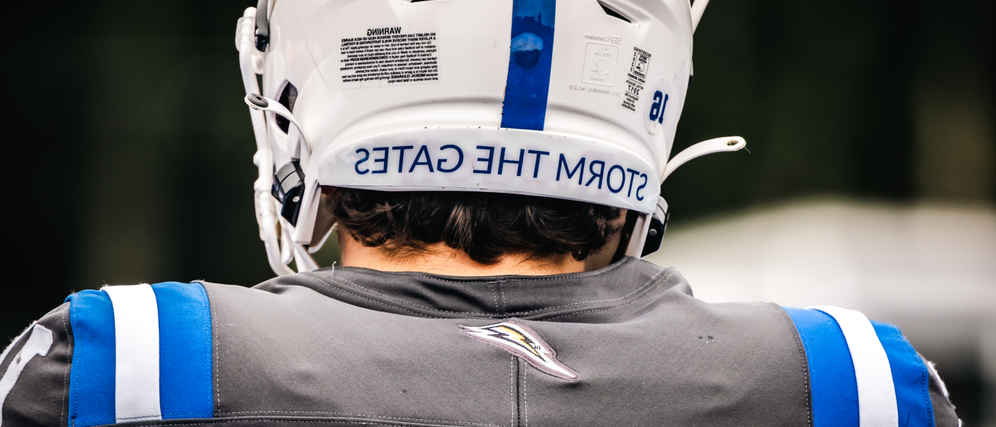 A football player's helmet reads "Storm the Gates"